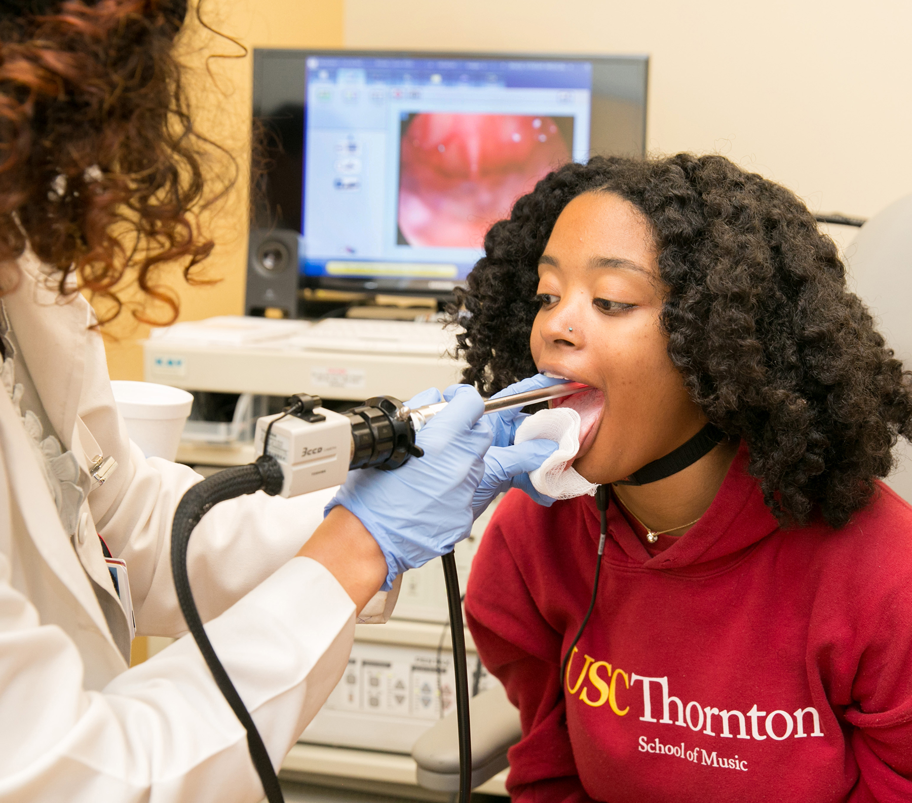 Doctor examines a female patient's vocal cords with an endoscope