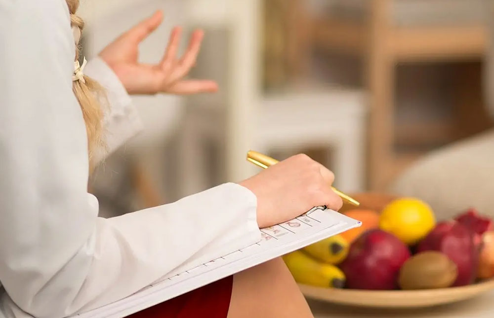 A nutritionist holds a pad of paper.
