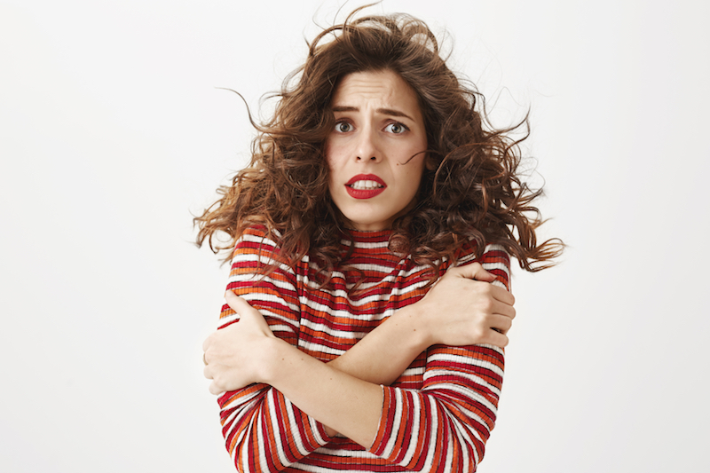 A woman with the chills crosses her arms over her chest