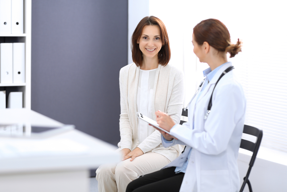 A woman speaks to her doctor at her annual physical exam