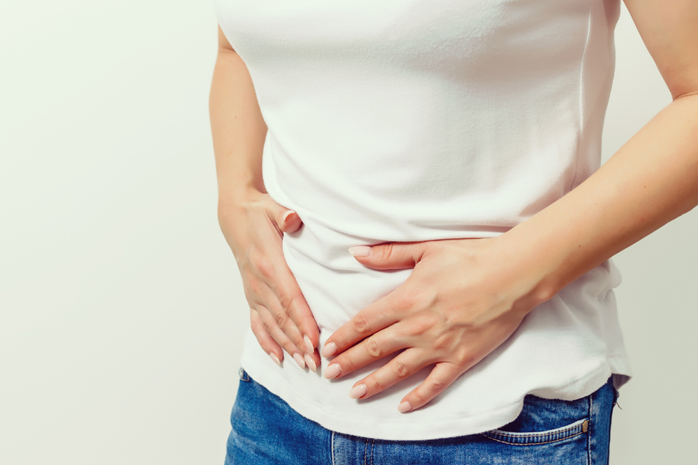 Photo of woman clutching her stomach in pain