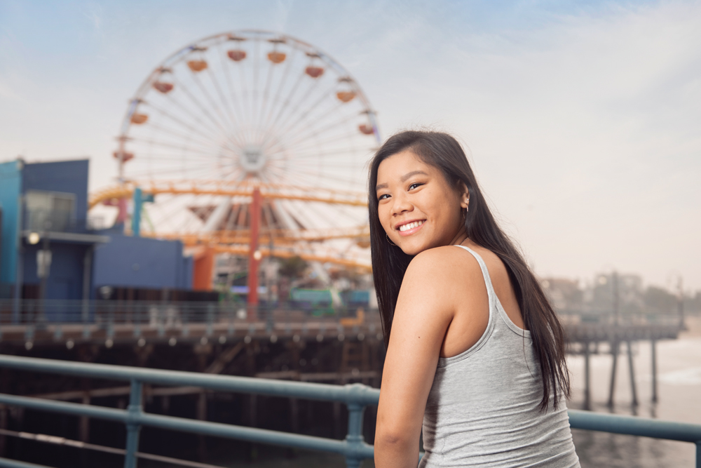 Gymnast and orthopedic surgery patient Anna Glenn sits in the foreground of a Ferris wheel