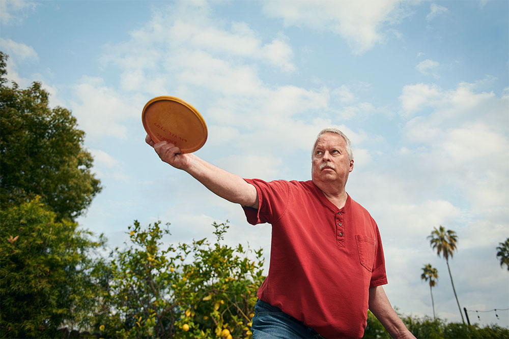 Roger Bignell, a triple bypass patient at USC Arcadia Hospital,, throws a disc golf disc in a Pasadena yard