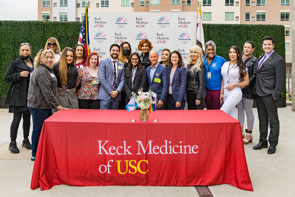 Healthcare providers and medical staff from the Gender-Affirming Care Program standing in front of a table outside of Keck Medicine of USC.