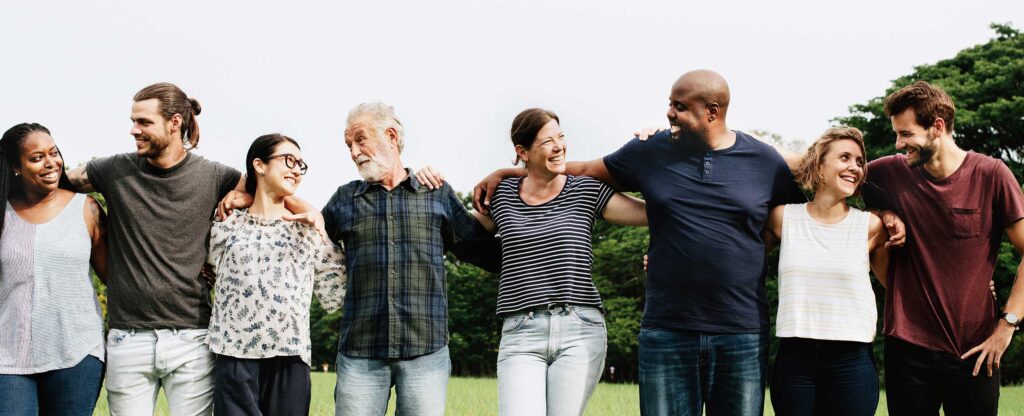 A diverse group of people hugging each other in the park