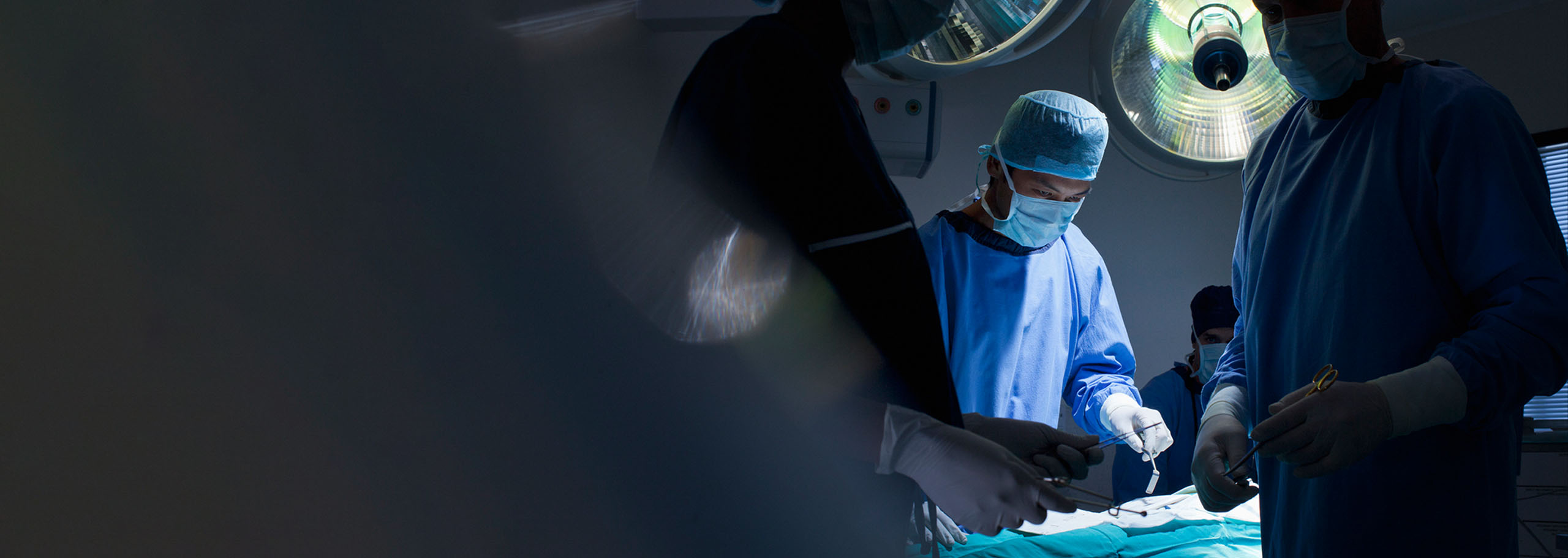 Medical team performing surgical operation in modern operating room.