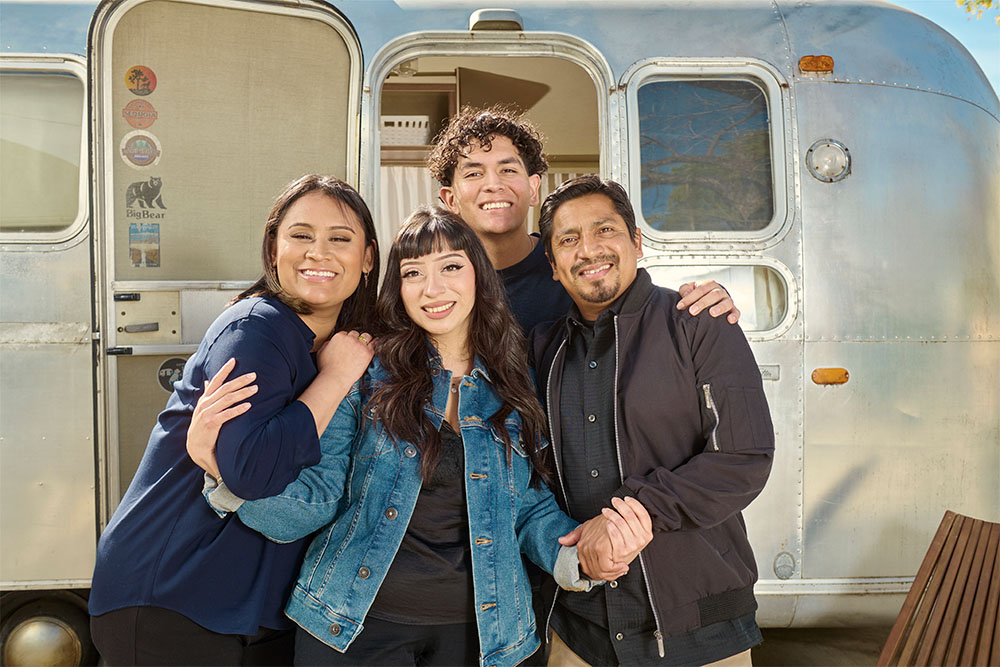Four siblings involved in a rare transplant exchange embrace outside the door of an Airstream trailer