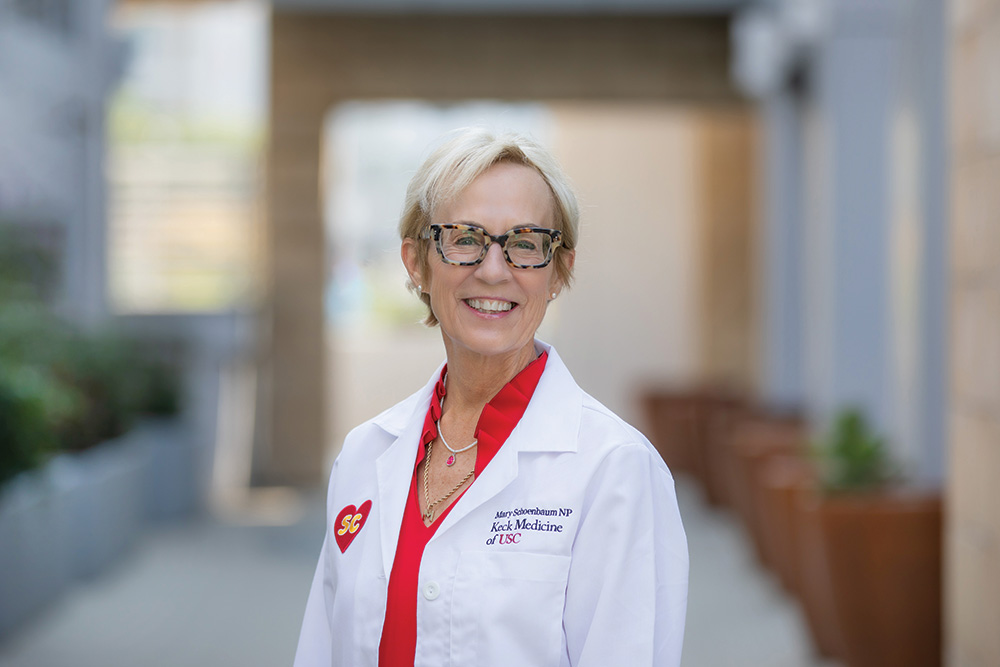 Nurse practitioner Mary Schoenbaum smiles outdoors in a white Keck Medicine lab coat