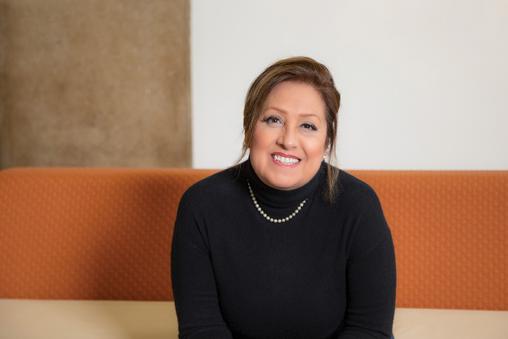 Christine Valenzuela, a co-chair for the patient and family advisory council, smiles in a black turtleneck