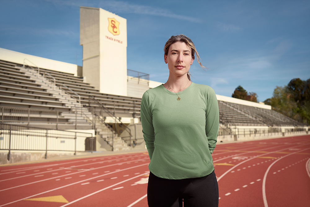 Céline Comolet stands on the USC track in a green workout shirt