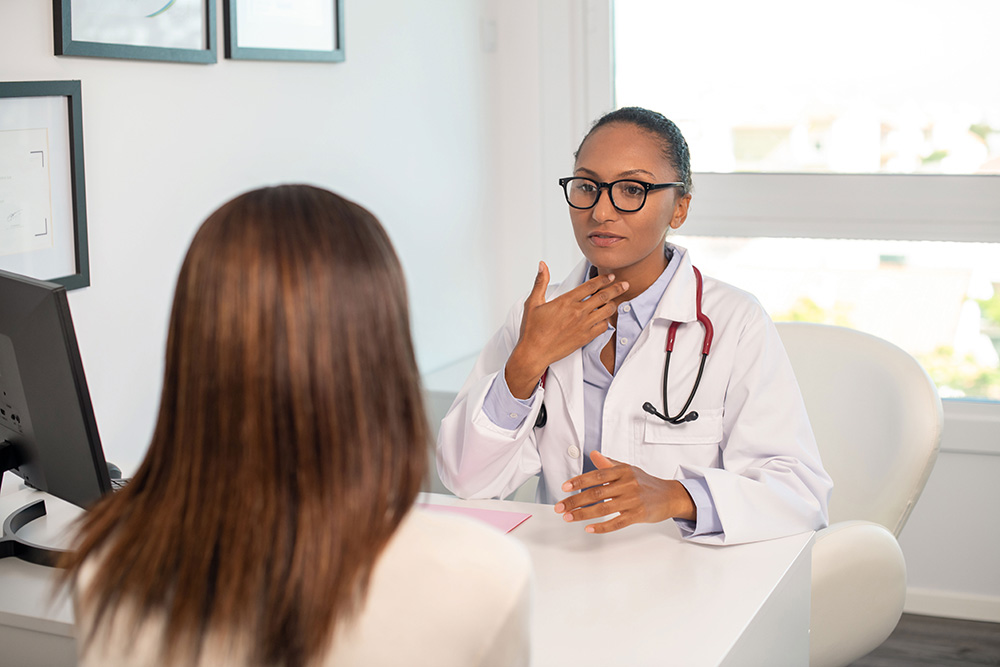 Female doctor talks to patient about potential head and neck cancer surgery.
