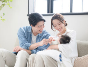 A family of three relaxing in a sunlit living room.