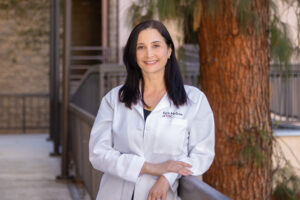Dr. Sarah Seibani stands outside and smiles.