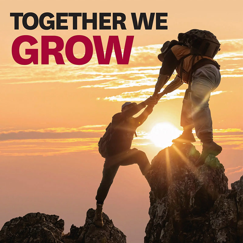 Two people mountain climbing at sunset