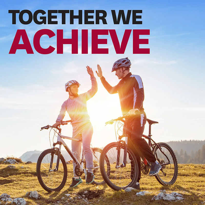 A male and female riding mountain bikes.