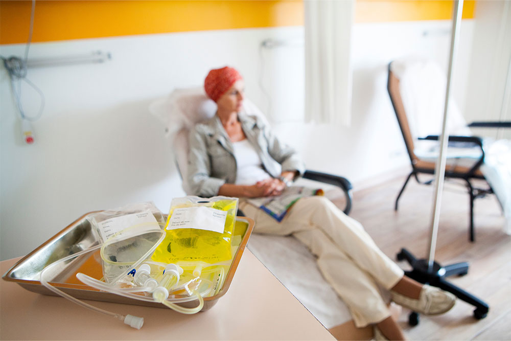 A cancer patient sits in a chair during chemotherapy.