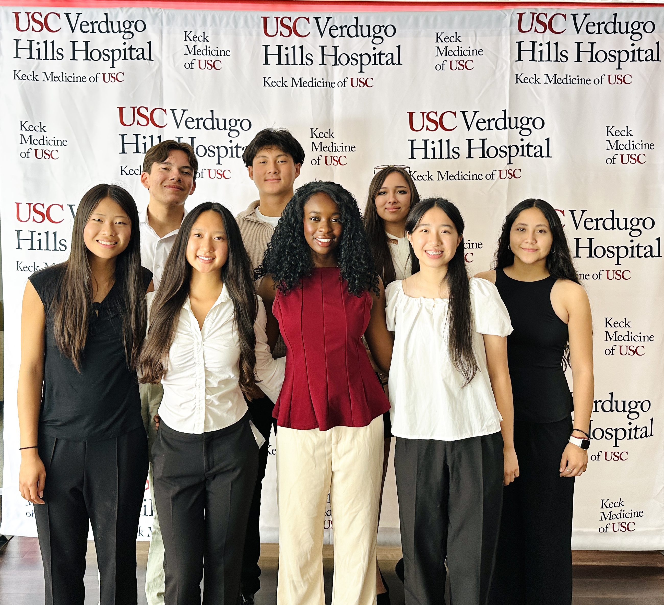 A group of students stand in front of USC Verdugo Hills Hospital backdrop